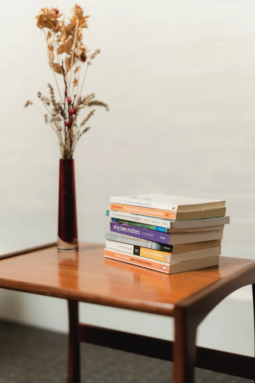 Books and dried flowers on a side table in the therapy room