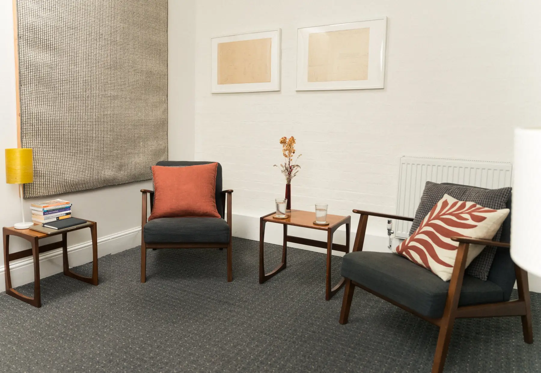 A calm therapy room with two armchairs, a lamp and side tables